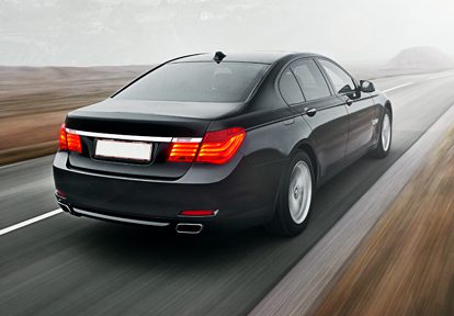 Auto Plus Insurance Group LLC | black car with red tail lights driving on the interstate in the desert